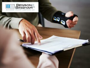 Client with wrist brace shaking hands with a representative from Benson Bingham Accident Injury Lawyers, LLC