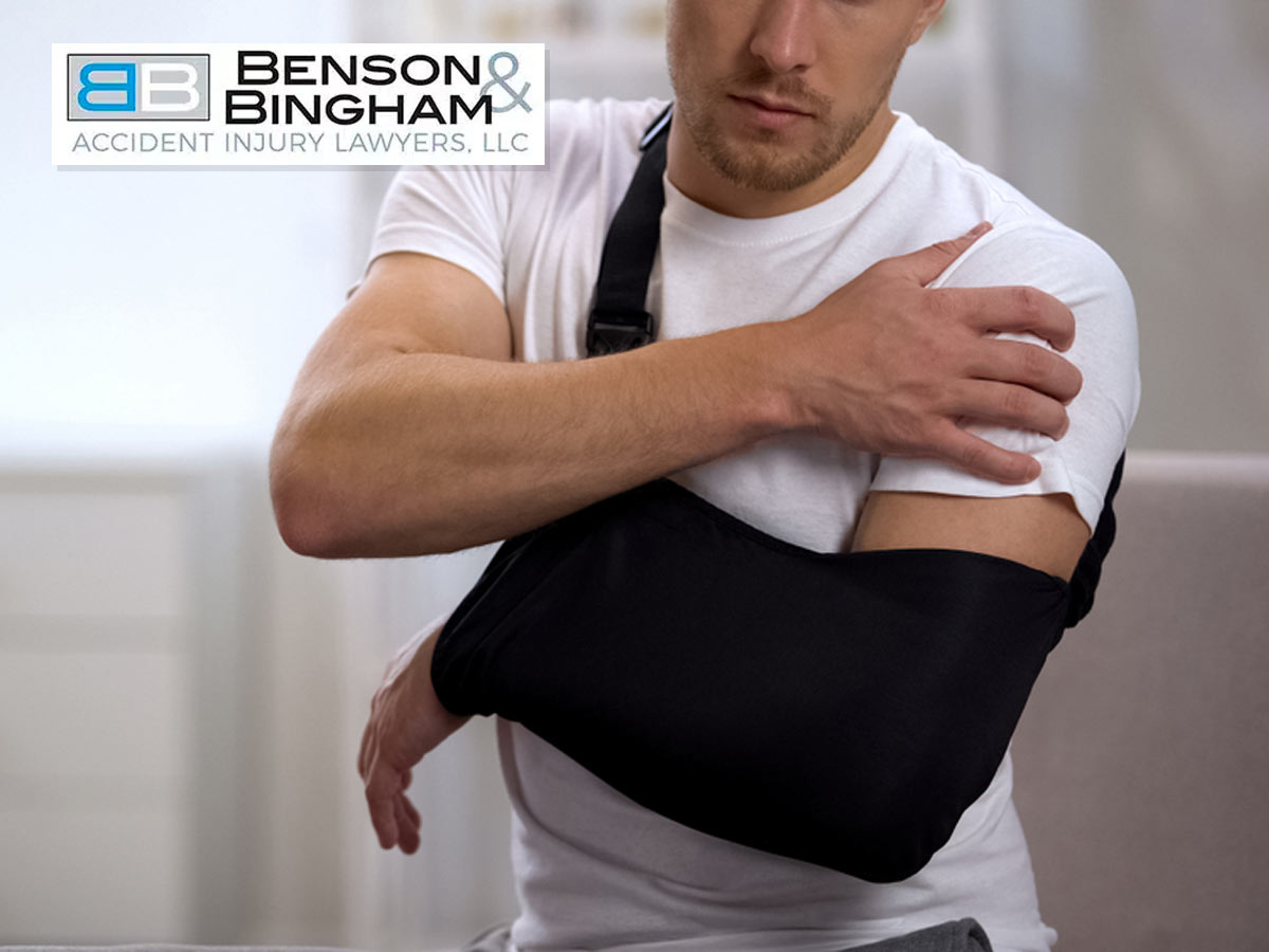 Man with arm in sling considering a personal injury claim, seeking legal assistance from Benson & Bingham Accident Injury Lawyers