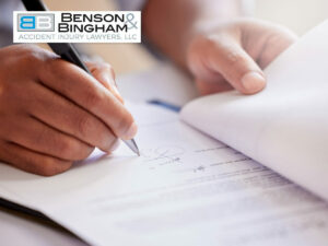 person signing legal documents to finalize a Settlement agreement with Benson & Bingham Accident Injury Lawyers